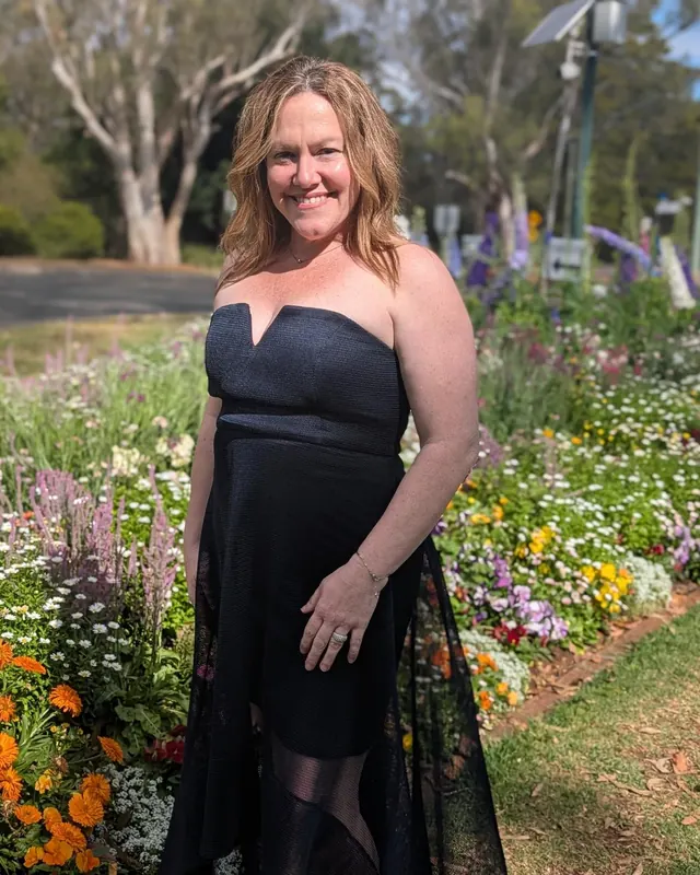 Amanda Best smiling in a flower garden